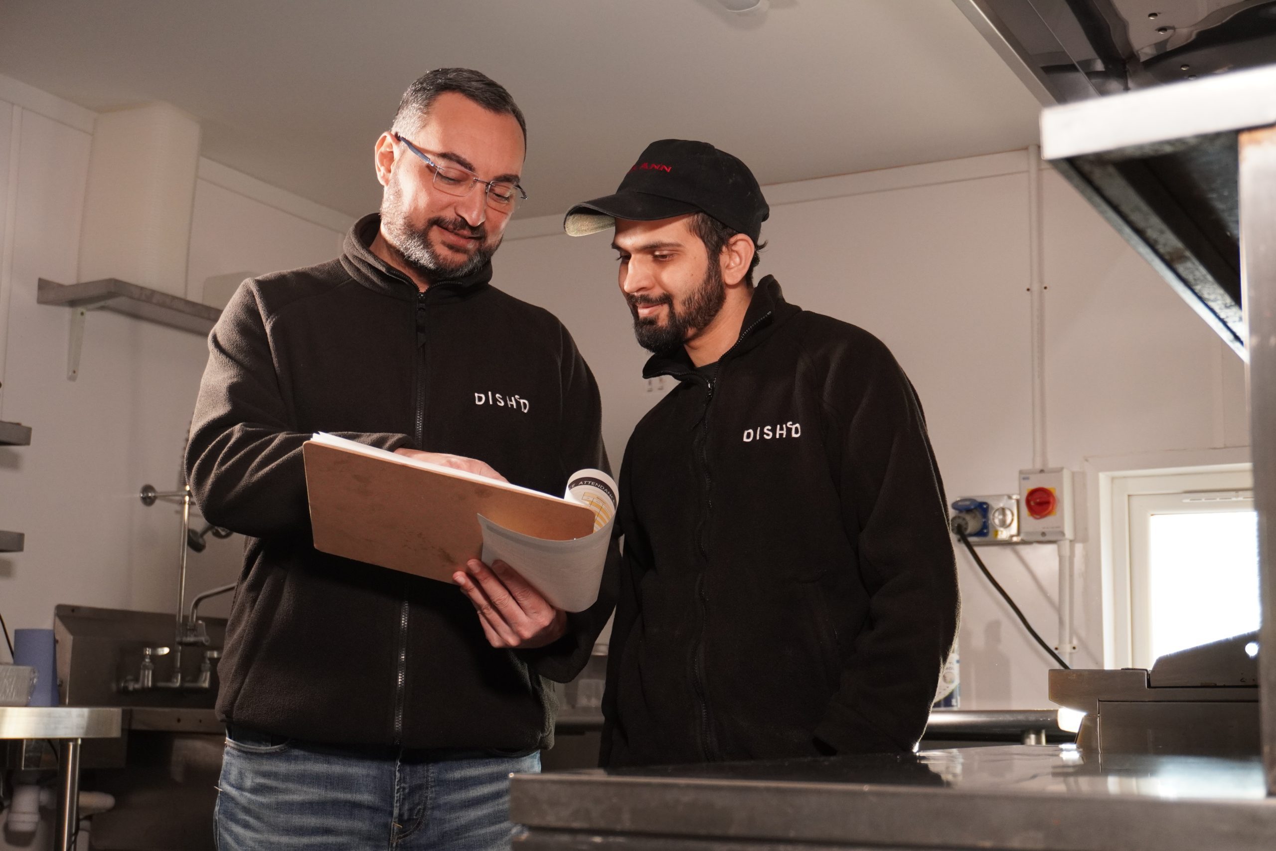 Two Dish’d team members reviewing kitchen operations in a commercial kitchen space.